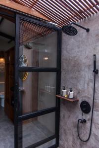 乌布IPIAN Angel by Pramana Villas的带淋浴的浴室,带玻璃门