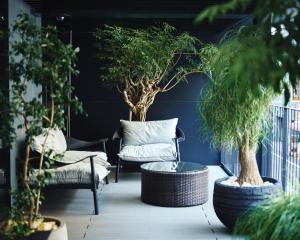 东京NOHGA HOTEL UENO TOKYO的一个带椅子和桌子的庭院,种有植物