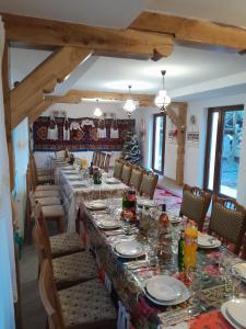 BîrsanaPensiunea Malinul的一间带长桌和椅子的用餐室