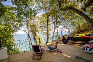 瓦尔纳Къщички Синьо лято, Черноморец - Варна - Blue Summer Houses Varna的吊床、桌椅和大海