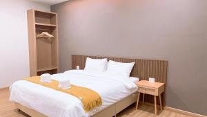 Ban Phraek Saดิ อัยย์ชญา โฮเทล的卧室配有一张白色大床和木制床头板