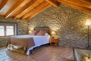普奇塞达加尔莫如福斯酒店的卧室配有一张石墙床