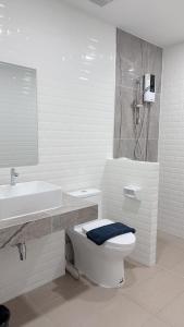 Ban Phraek Saดิ อัยย์ชญา โฮเทล的白色的浴室设有卫生间和水槽。