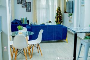 利隆圭Crystal Apartments Area 43的客厅配有蓝色的沙发和白色的椅子
