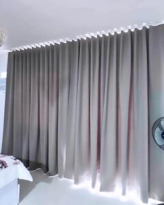 公主港Condo Home in Puerto Princesa near PPS Airport的卧室窗户上的窗帘