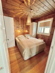 GaustablikkGausta Lodge med 6 sengeplasser i nærhet til Gaustatoppen的一间卧室设有一张床和木制天花板