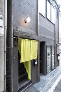 神户かゑる屋的建筑的侧面有黄色窗帘