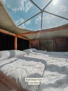 KhuloGlamping Tago的屋顶客房内的一张白色大床