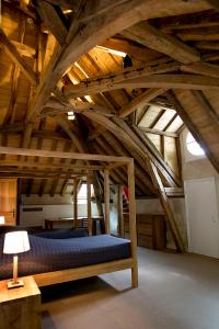 阿姆博斯Château de Perreux, The Originals Collection的木制天花板的客房内配有一张床。