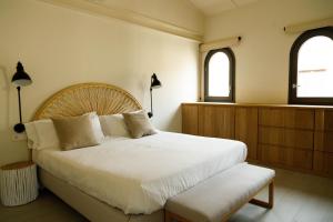 赫罗纳La Comuna by Bon Dia Residences的卧室设有一张白色大床和两个窗户。