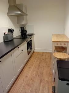 LincolnshireColville House的厨房铺有木地板,配有白色橱柜。