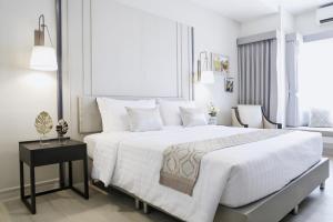 梭桃邑THE NAVY HOUSE HOTEL的白色卧室配有一张大床和一张桌子