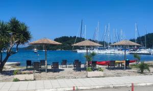 奈德里Oscar Hotel Lefkada的海滩上的一组椅子和遮阳伞,有船