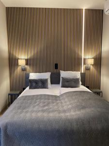 阿尔登堡De Stadspoort appartementen的一间卧室配有一张大床和两盏灯