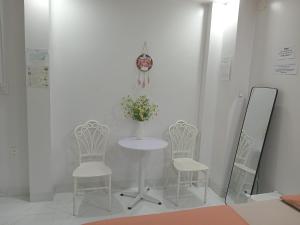 顺化Huế Thơ Homestay的一张桌子、两把椅子和一个花瓶