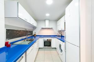 格拉纳达tuGuest Avenida de la Investigación的厨房配有白色橱柜和蓝色台面