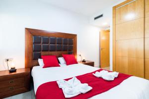 格拉纳达tuGuest Avenida de la Investigación的卧室配有带红色枕头的大型白色床