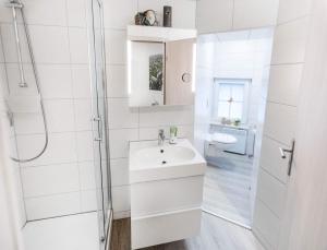 Frose"Altes Stellwerk Frose" am Froser See的白色的浴室设有水槽和淋浴。