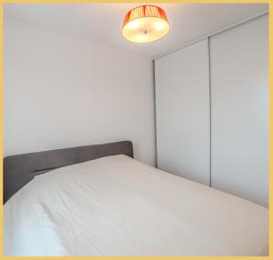 圣朱利安恩因Appartement T2 Moderne St Julien的卧室配有白色的床和灯