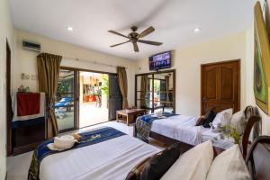 邦萨雷Siam Court Hotel and Resort的客房设有三张床和吊扇。