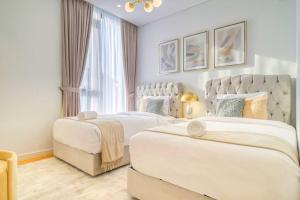 迪拜Livbnb - Elegant 3BR+Maid, Sea View in Bluewaters的一间卧室设有两张床和大窗户