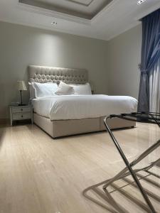 利雅德GAZLA的白色卧室配有床和玻璃桌