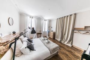 阿维尼翁拉蒂曼诗旅馆的卧室配有一张带白色床单和枕头的大床。