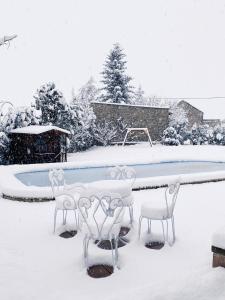 IpiésBorda de Fadrín的一座带桌椅的雪覆盖的游泳池