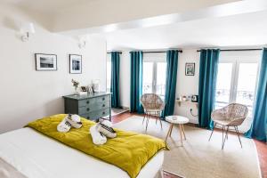 阿维尼翁拉蒂曼诗旅馆的一间卧室配有蓝色窗帘、一张床和一张书桌