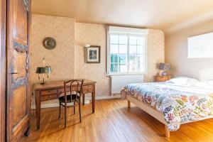 TrégarvanTy Ar Bleiz Gwenn - La maison du Loup Blanc的一间卧室配有一张床、一张书桌和一个窗户。