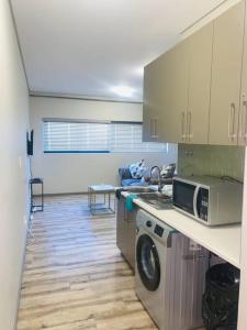 温特和克DMN City Merensky Apartment的厨房配有洗衣机和微波炉。