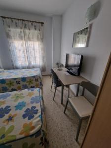 Talavera la Real塔拉韦拉旅馆的一间卧室配有书桌、一张床和一台笔记本电脑