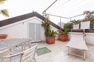 米兰Monte Napoleone Split-level Terrace Apartment - Top Collection的阳台配有桌椅和植物