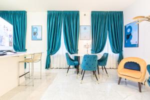 米兰Monte Napoleone Split-level Terrace Apartment - Top Collection的一间配备有蓝色椅子和桌子的用餐室