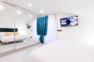 米兰Monte Napoleone Split-level Terrace Apartment - Top Collection的一间卧室配有一张床、一台电视和一面镜子