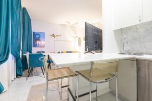 米兰Monte Napoleone Split-level Terrace Apartment - Top Collection的厨房配有白色的柜台和椅子