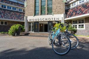 宰斯特Hotel Woudschoten的停放在大楼前的两辆自行车