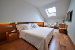 潘普洛纳珍珠大酒店的卧室配有一张白色大床和天窗