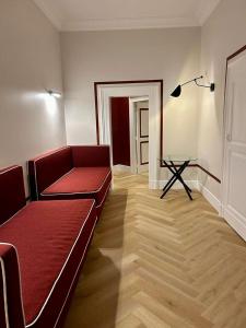 那不勒斯雷丽斯黛拉佩特旅馆的客厅配有红色的沙发和桌子