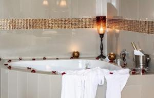 贝尔维尔Ridgeworth Boutique Guesthouse的带浴缸和白色毛巾的浴室