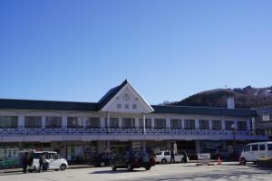 白马村The Hakuba Station Room的一座大型建筑,上面有钟