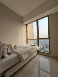 雅加达3BR Flat in Taman Anggrek Residence的一间卧室设有一张大床和大窗户