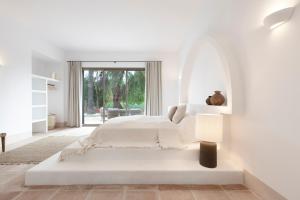 科因Finca La Familia Naranja的白色卧室配有床和灯
