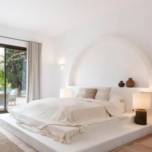科因Finca La Familia Naranja的白色的卧室设有一张大床和一个窗户