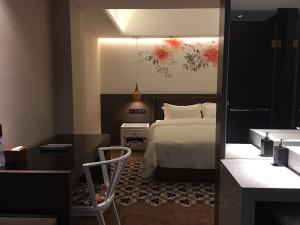 广州柏高雅酒店(广州东圃天河城店)的一间卧室配有一张床和一张桌子及椅子