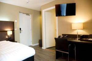 鲁尔蒙德鲁尔蒙德隔壁酒店的酒店客房配有一张床、一张书桌和电话