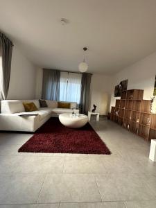 BonerathFerienwohnung Eira的客厅配有白色沙发和红色地毯。