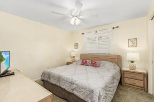 珊瑚角Villa Catalina Isles - Holidays in Paradise的一间卧室配有一张床和吊扇