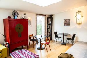 布格奈斯Le nid du massereau的客厅配有红色橱柜和桌子