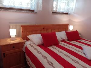 弗济内Apartman Centar Fužine的一间卧室配有一张带两个红色和白色枕头的床